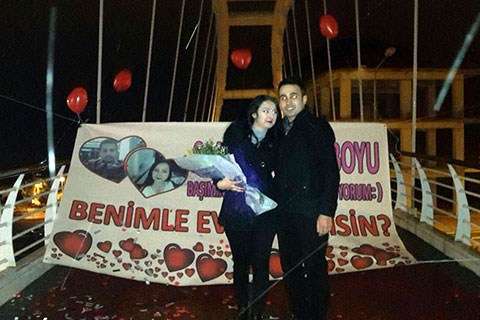 Üst geçitte pankartlı konfetili evlenme teklifi
