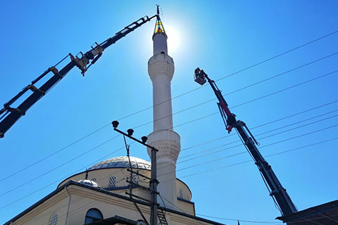 Depremde zarar gören minarenin külah kısmını itfaiye indirdi