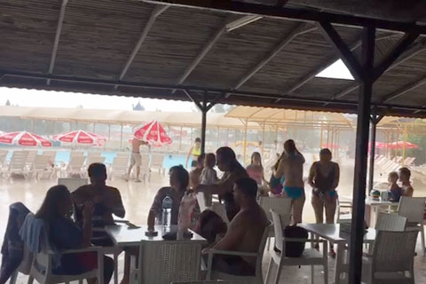 Tatilciler yağmura havuzda yakalandı